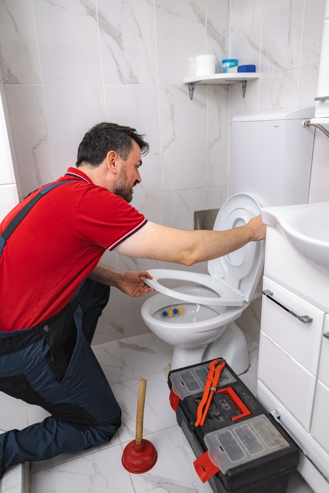 a man fixing the toilet